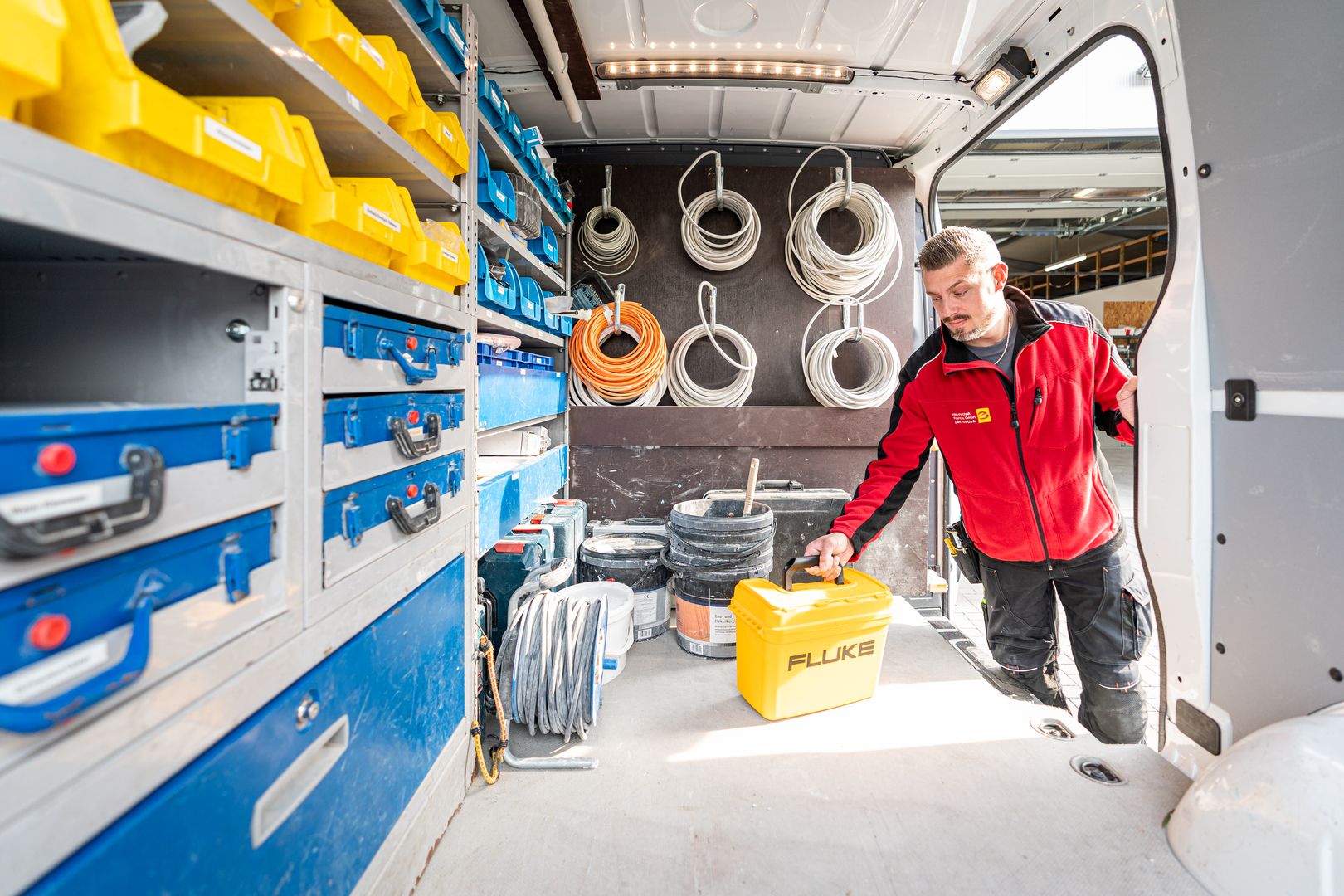 Elektriker lädt Material in einen Van